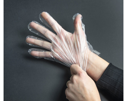 Een hand die een transparante wegwerphandschoen aantrekt