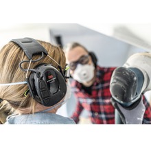 Persoon met 3M Peltor ProTac III gehoorbeschermingshoofdtelefoon aan het werk
