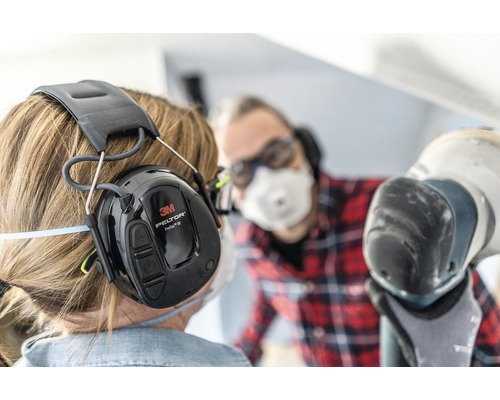 Persoon met 3M Peltor ProTac III gehoorbeschermingshoofdtelefoon aan het werk