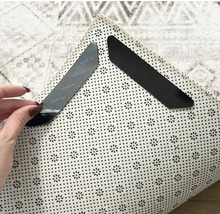 Twee antislip-hoekstukken voor tapijten op een tapijt om te bevestigen en te fixeren.