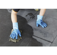 Persoon reinigt tegels met een doek en handschoenen.