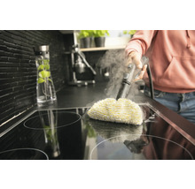 Stoomreiniger in gebruik op een kookplaat in een keuken.