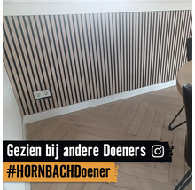 Wanddecoratie met houten panelen en visgraat parketvloer in een lichte ruimte.