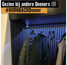 Moderne garderobe met jassen aan hangers onder indirecte verlichting