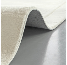 Detailopname van een lichtgekleurd vloerkleed met pool en rug