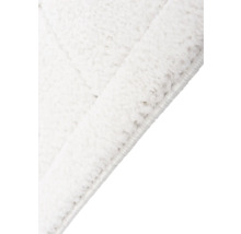 Detailopname van een wit vloerkleed met hoogpolig oppervlak