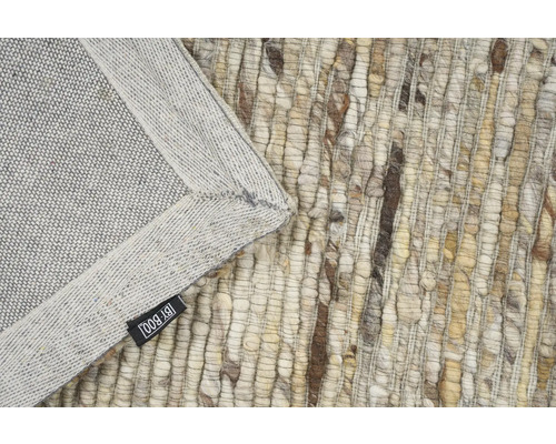 Detailaanzicht van een vloerkleed met franjes en het By Boo logo.