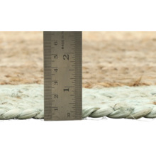 Detailopname van een vloerkleed met een meetlint om de hoogte te meten