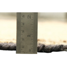 Detailopname van een tapijt met een meetinstrument om de dikte van het tapijt te bepalen.