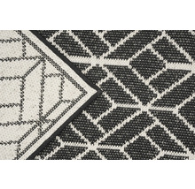 Detail van een zwart-wit buitentapijt met geometrisch patroon.
