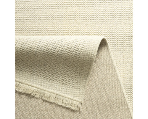 Beige tapijt met franjes en geweven textuur