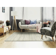 Woonkamer met vloerkleed, bank, fauteuil, vloerlamp en dressoir