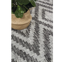 Vloerkleed met geometrisch patroon en plant in mand