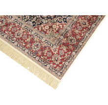 Detail van een rood tapijt met bloemmotief en franjes
