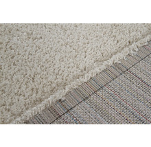 Detailopname van een beige shaggy tapijt met lange pool