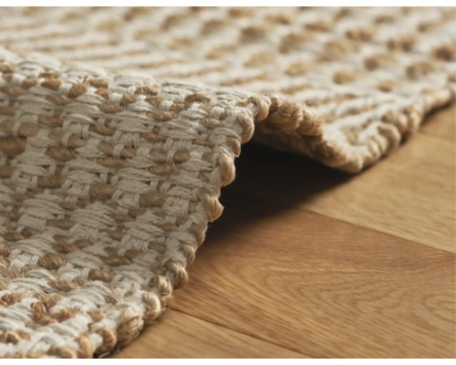 Detail van een gevlochten vloerkleed op een houten vloer