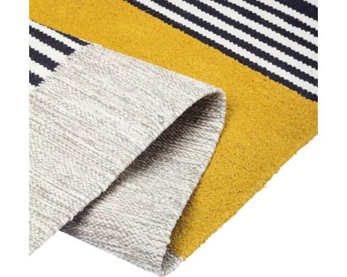 Detailweergave van een vloerkleed met streepmotief en opgerolde rand