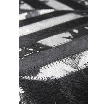 Detailopname van een zwart-wit vloerkleed met zigzagpatroon van vacht