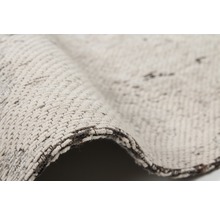 Gedetailleerde weergave van een beige tapijt met textielpatroon