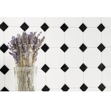 Decoratieve tegelwand met geometrisch patroon en een bos lavendel in een glas.