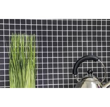 Decoratieve groene sprieten en een waterketel voor een wand met mozaïektegels