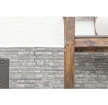 Detailopname van een stenen wandbekleding en een houten element