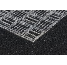 Detailopname van een zwart tapijt met grijs zigzagpatroon
