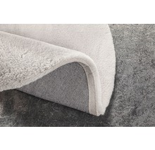 Detailweergave van een lichtgekleurd tapijt met textielrug