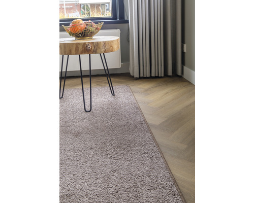 Woonkamer met vloerkleed, houten tafel en parketvloer