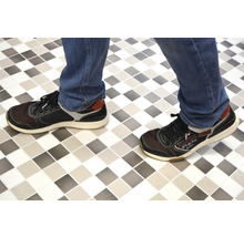 Persoon met schoenen op tegelvloer