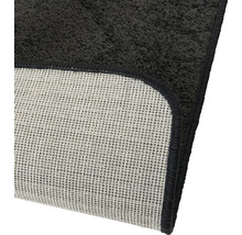 Detailweergave van een zwart badtapijt met antislip achterkant