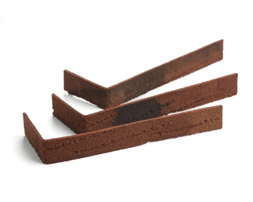 Drie roodbruine hoekstukken van baksteenstrips op een witte achtergrond