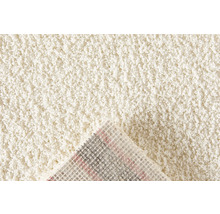 Detailopname van een beige tapijt met hoogpolig oppervlak