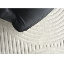 Detailopname van een tapijt met geometrisch patroon en een meubelstuk