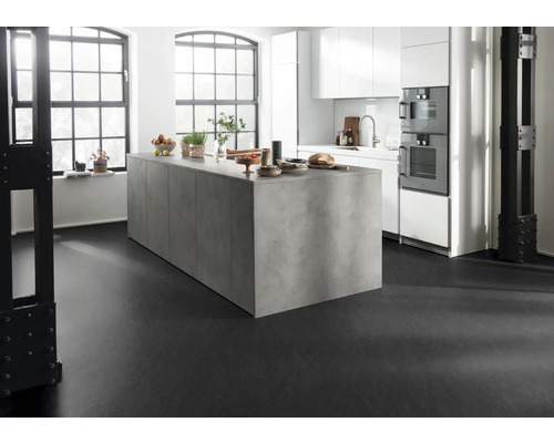 Lichte keuken met kookeiland, witte kasten en zwarte vloer.