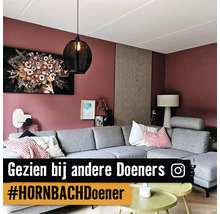 Woonkamer met grijze hoekbank, hanglamp en wanddecoraties