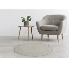 Woonkameropstelling met rond vloerkleed, fauteuil en bijzettafel met plant