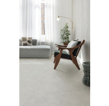 Lichte woonkamer met bank, fauteuil, vloerlamp en kamerplant