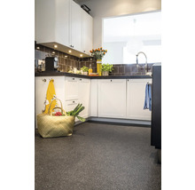 Lichte keuken met aanrecht, kasten, tegels en een mand op de vloer.