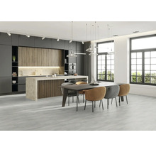 Moderne keuken met kookeiland, eettafel en stoelen in een lichte ruimte.