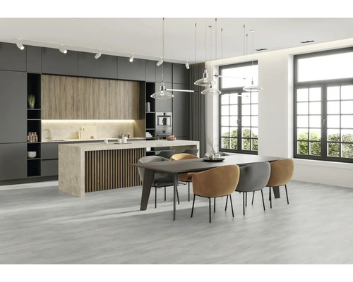 Moderne keuken met kookeiland, eettafel en stoelen in een lichte ruimte.