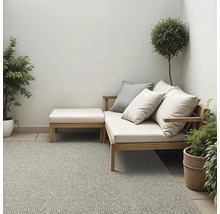 Inrichtingsidee voor buiten met loungesofa, kussens, voetenbank, vloerkleed en planten