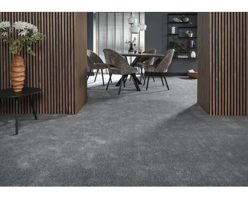 Interieur met grijze vloerbedekking, eettafel met stoelen, houten wandbekleding en decoratieve elementen.