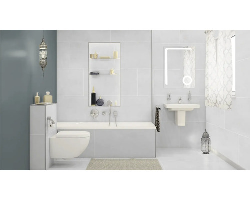 Lichte badkamer met bad, wastafel, toilet en decoratie
