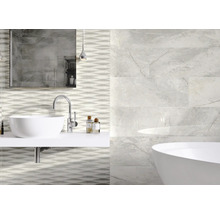 Badkamer met wastafel, spiegel, bad en wandtegels met marmerlook en golfpatroon
