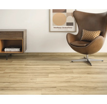 Lichte woonkamer met laminaatvloer, fauteuil en commode