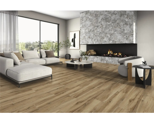Woonkamer met bank, fauteuil, open haard en houtlook vloertegels voor een lichte, ruime sfeer.
