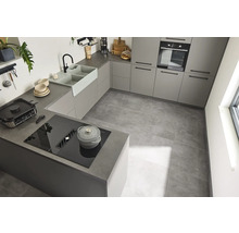 Lichte keuken met inbouwkasten, spoelbak, kookplaat en tegelvloer.