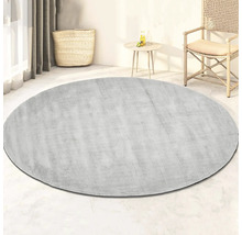 Rond vloerkleed in de woonkamer met mand, tafel en stoel