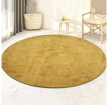 Rond vloerkleed in woonkamer met rotan stoel en bijzettafel